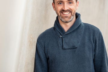 Hanno Dietrich. Breit lächelnder Mann mit blauen Pullover, Bart und kurzen Haaren. Zuständig für Beratung, Coaching, Fortbildungen, Konfliktmanagement, Moderation, Organisationsentwicklung & Supervision.
