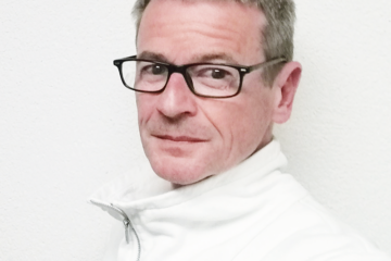 Joachim Maier. Mann mit kurzen Haaren und dunkler eckiger Brille und weißen Pullover. Zuständig für Beratung, Coaching, Fortbildungen, Moderation, Organisationsentwicklung & Supervision.