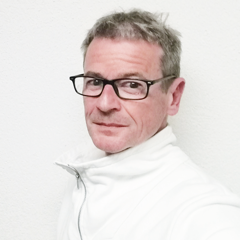 Joachim Maier. Mann mit kurzen Haaren und dunkler eckiger Brille und weißen Pullover. Zuständig für Beratung, Coaching, Fortbildungen, Moderation, Organisationsentwicklung & Supervision.